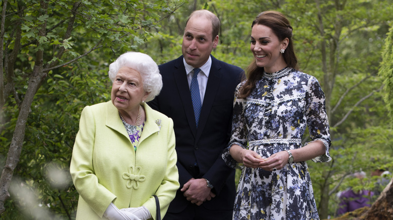 Queen Elizabeth, Prince William, and Kate Middleton smiling for a group photo
