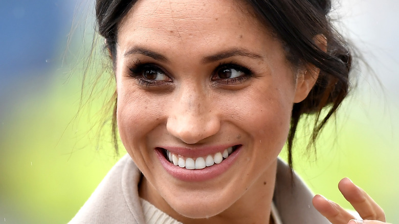 Meghan Markle smiles and waves