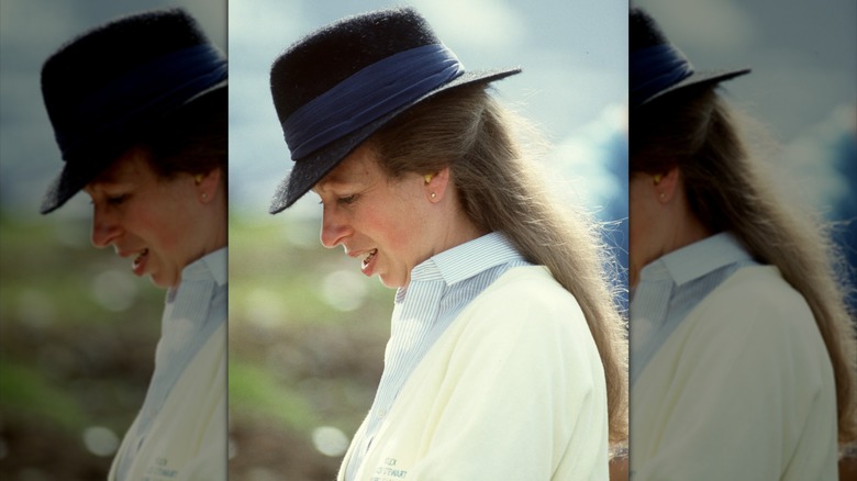 Princess Anne looking down at something in her hands