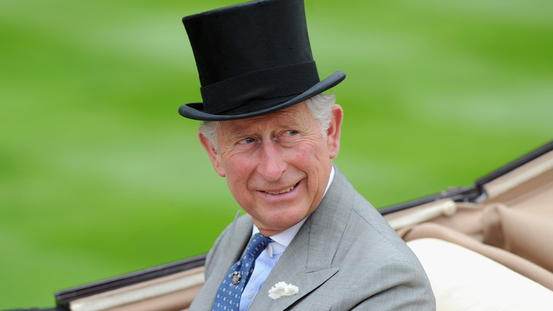 King Charles wearing top hat smiling 