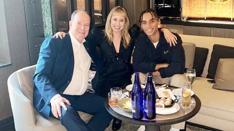 Prince Albert II smiling with Jazmin Grace Grimaldi and Alexandre Grimaldi at drinks in bar