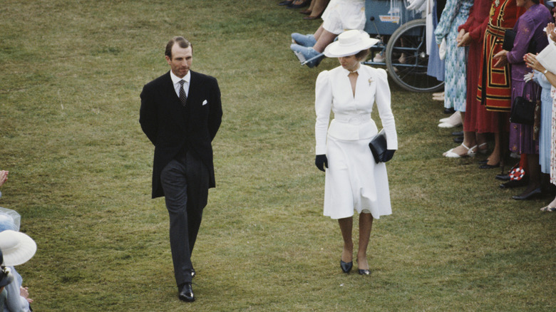 Captain Mark Phillips and Princess Anne in 1985 walking on lawn at formal event with distance between them