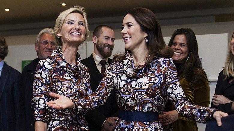 Princess Mary of Denmark and Nina Wedell-Wedellsborg smiling in matching dresses