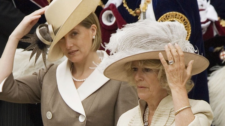 Wind-blown royals holding their hats