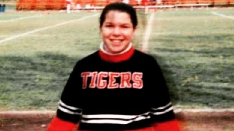 A young Ellen Latzen cheerleading on the sidelines of a football field