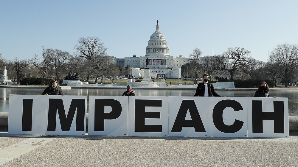 People outside the capitol with the impeachment sign