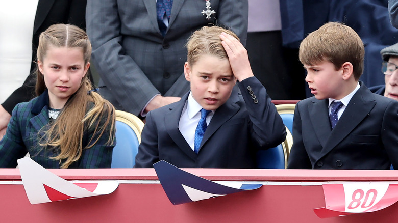 Princess Charlotte, Prince George, and Prince Louis sitting togethe
