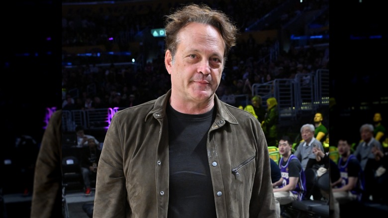Vince Vaughn looking serious with rumpled hair inside a stadium.