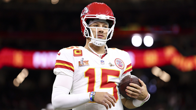 Patrick Mahomes holding a football under his arm