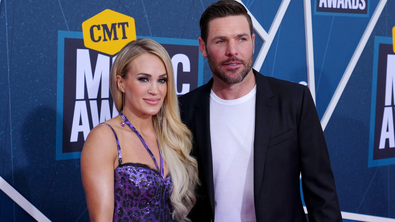 Carrie Underwood and Mike Fisher posing for photos