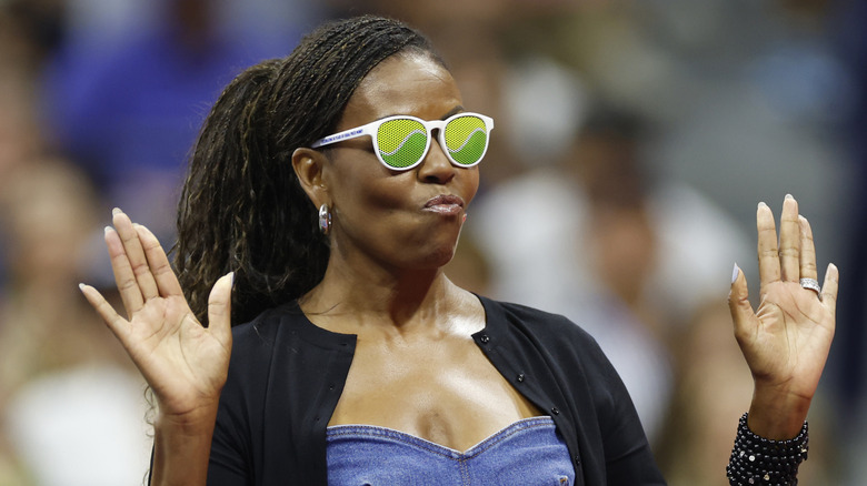 Michelle Obama wearing green tinted sunglasses.