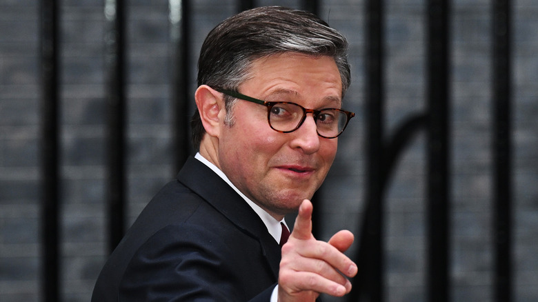 Speaker of the House Mike Johnson pointing at the camera and looking over his shoulder.