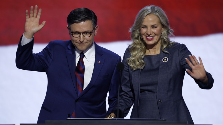 Speaker of the House Mike Johnson and his wife, Kelly Johnson, waving from podium.