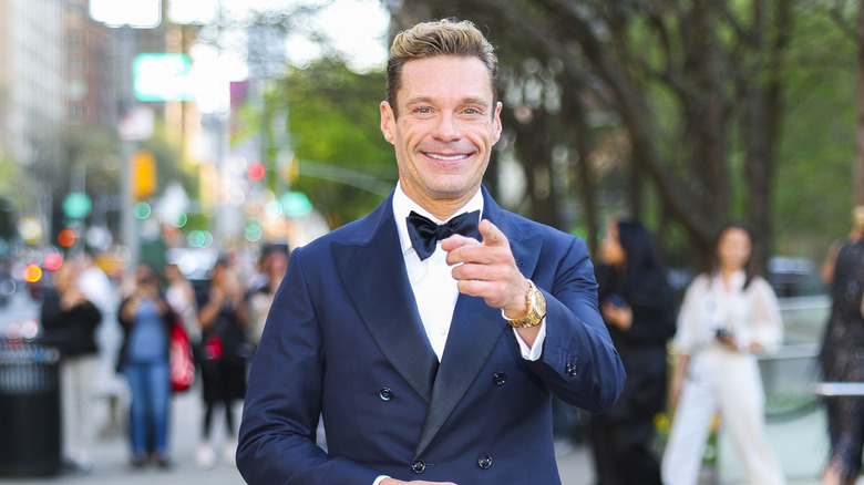 Ryan Seacrest smiling and pointing while at a film screening in New York City