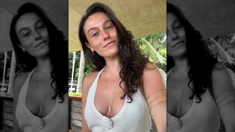 Aubrey Paige taking a selfie in a white knit dress.