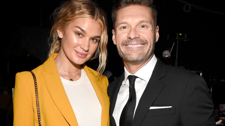 Shayna Taylor in yellow posing with Ryan Seacrest.
