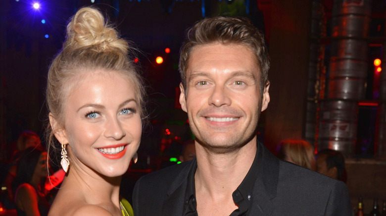 Ryan Seacrest and Julianne Hough smiling while posing together in 2012
