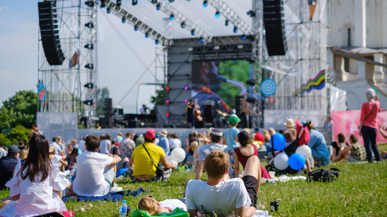 Crowd sitting outside at a music festival
