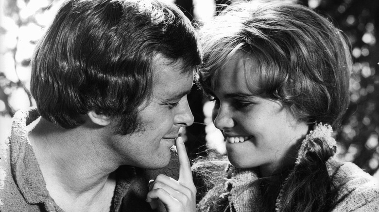 Robert Mitchum smiles as a young Sally Field puts her finger to his lips in "The Way West."