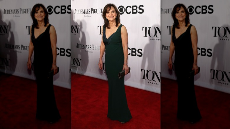 Sally Field tilting her head up and grinning in a green dress