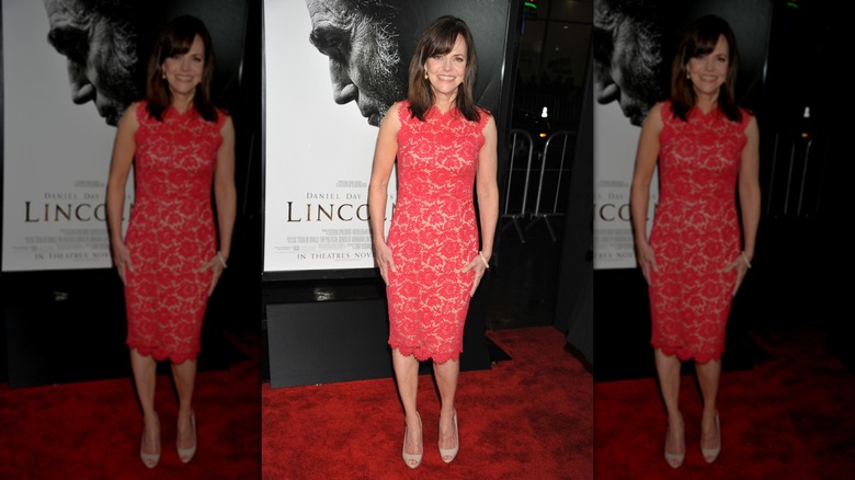 Sally Field smiling in a red lace dress