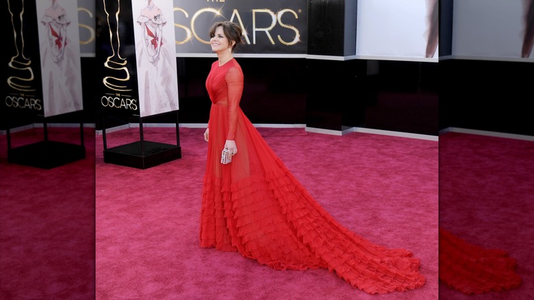 Sally Field smiling with the long train of her dress flowing behind her at the 2013 Oscars