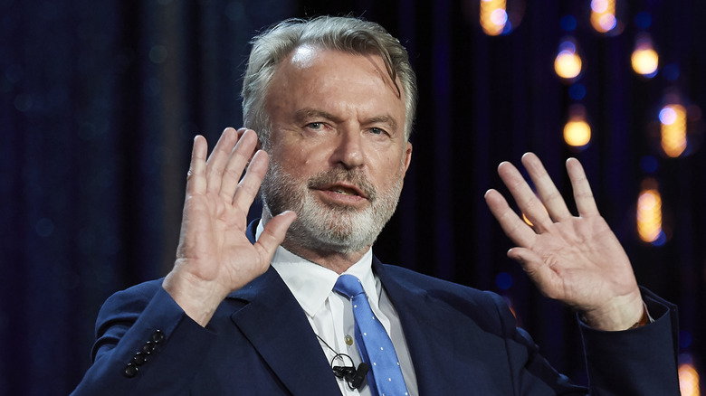 Sam Neill with his hands up