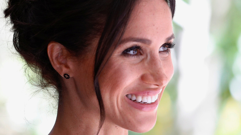 Meghan Markle smiling with her hair up