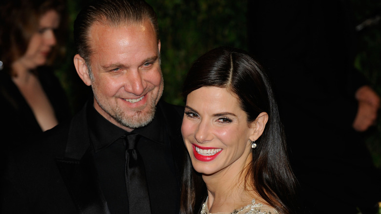 Closeup-up of Jesse James and Sandra Bullock smiling at event