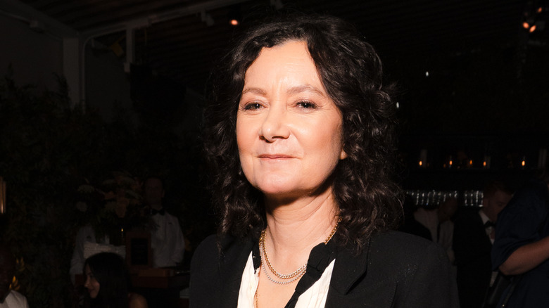 Sara Gilbert posing in front of a black background