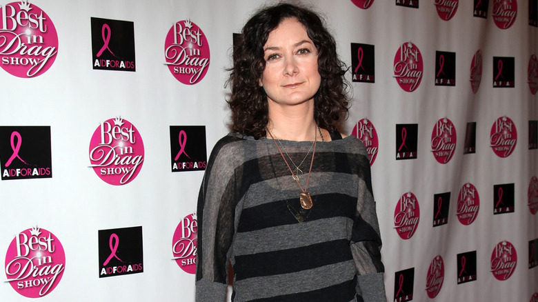 Sara Gilbert posing in front of a multicolored background
