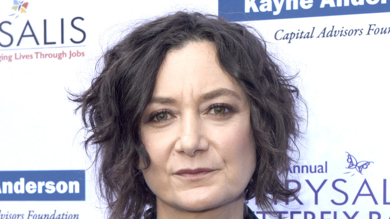 Sara Gilbert posing in front of a white background