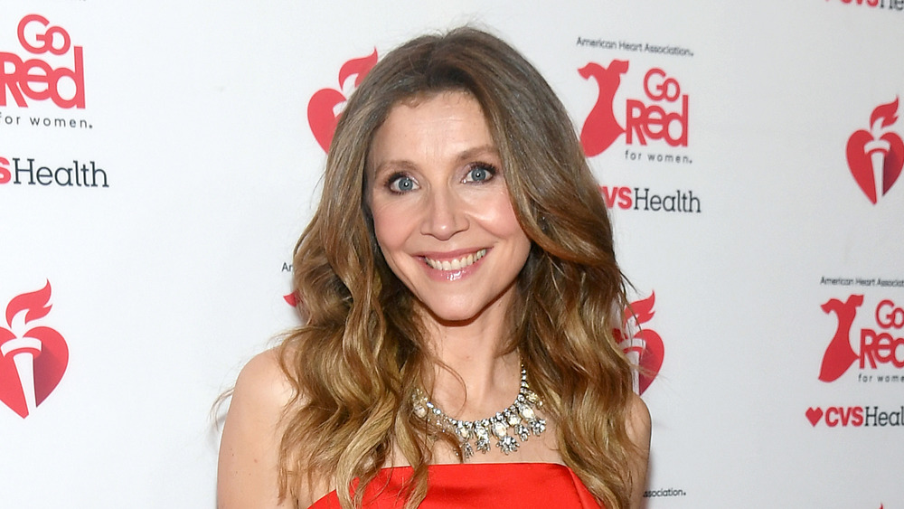 Sarah Chalke smiling on red carpet, red dress