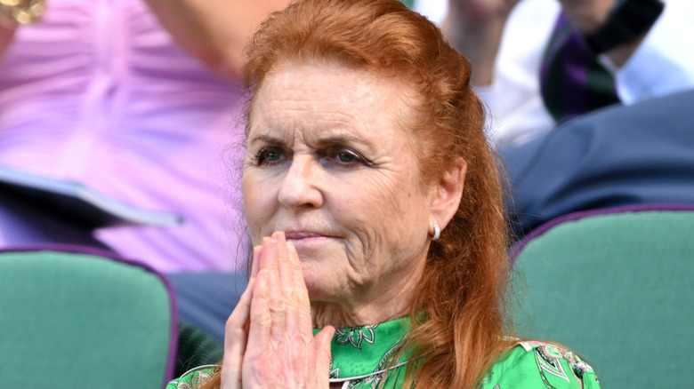 Sarah Ferguson holding her hands in a prayer position in a green patterned dress