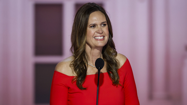 Sarah Huckabee Sanders red dress at microphone