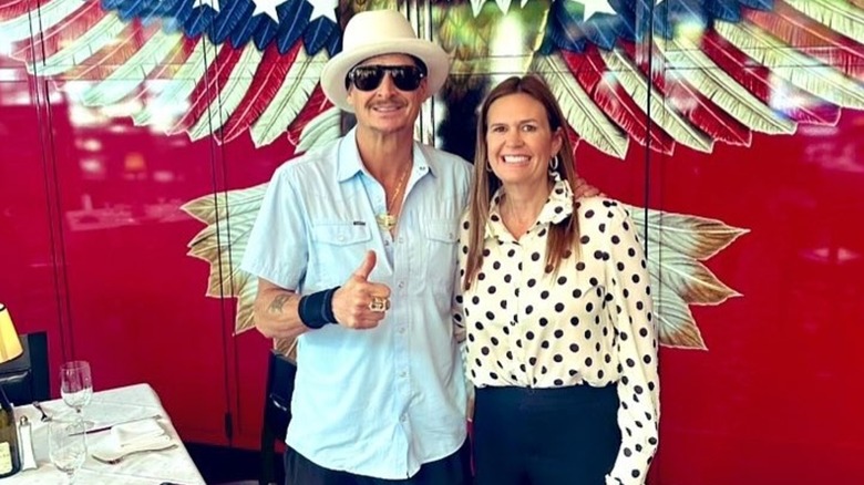 Kid Rock posing with Sarah Huckabee Sanders in front of a big eagle