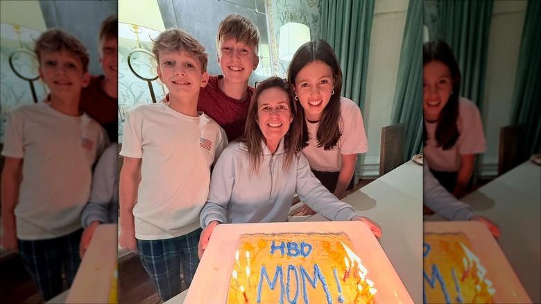 Sarah Huckabee Sanders smiling while wearing a grey sweater while surrounded by her kids.