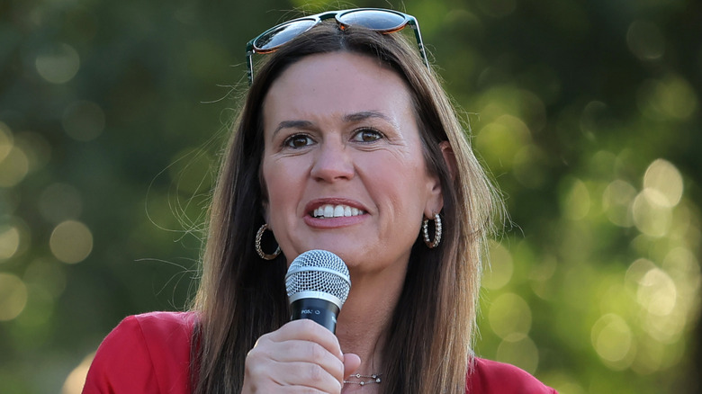 Arkansas Governor Sarah Huckabee Sanders speaking into a microphone