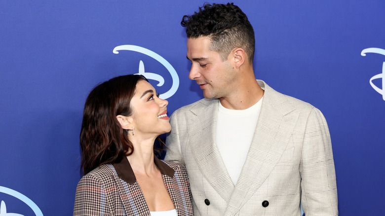 Sarah Hyland and Wells Adams smiling at each other on the red carpet