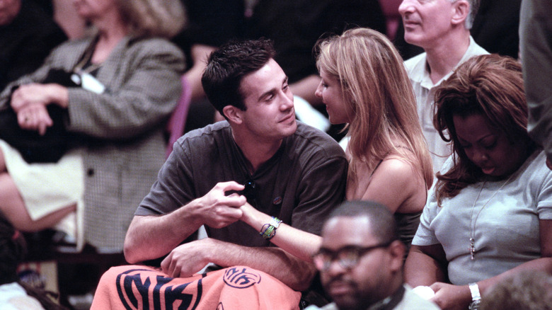 Freddie Prinze Jr. smirking and holding Sarah Michelle Gellar's hand