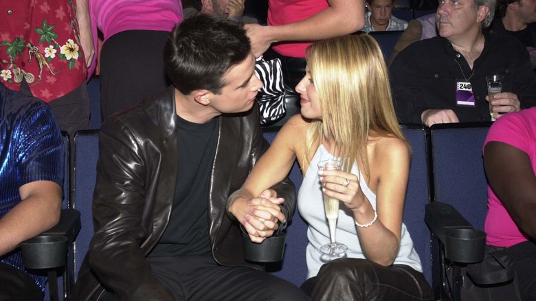 Freddie Prinze Jr. and Sarah Michelle Gellar sitting, holding hands, and looking at each other