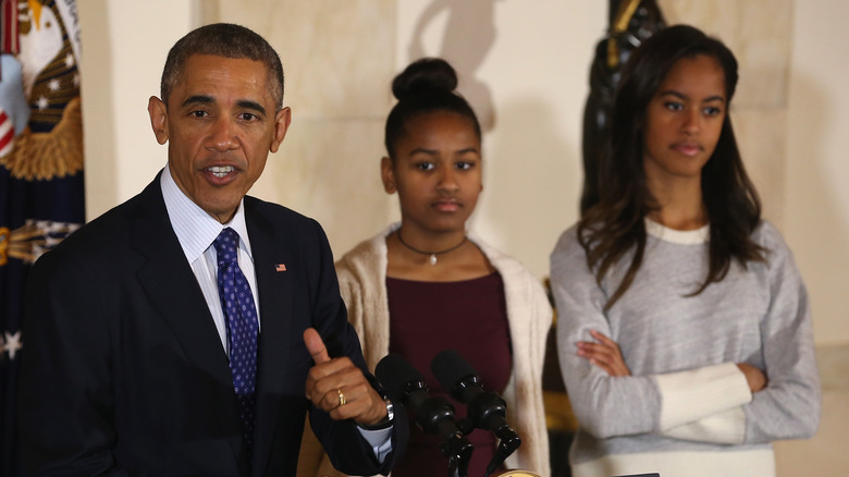 Sasha and Malia Obama standing behind Barack at turkey pardoning