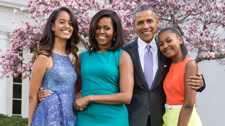 Malia, Michelle, Barack, and Sasha Obama posing for a picture in the White House garden
