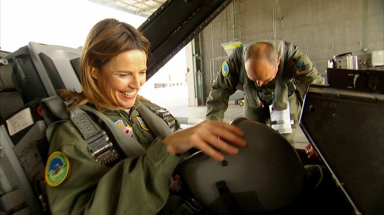 Savannah Guthrie smiles inside an F16 while Camron Guthrie stands outside of it