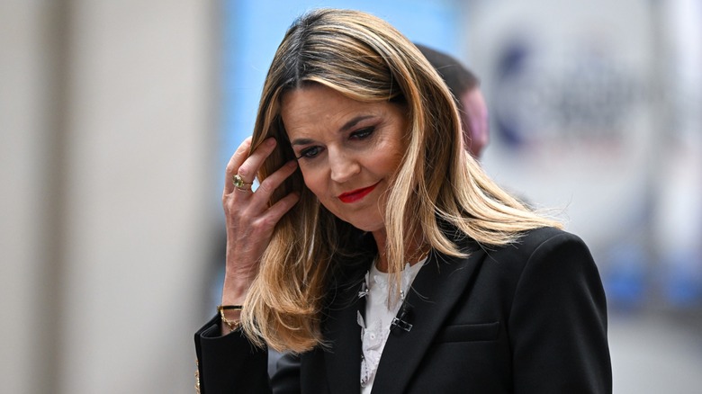 Savannah Guthrie looking down and tucking hair behind her ear