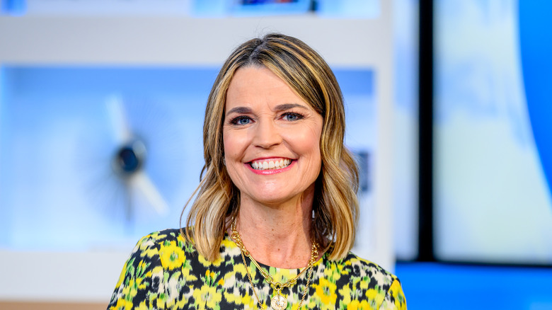 Savannah Guthrie smiling in a yellow dress while sitting down in the 'Fox & Friends' studio.