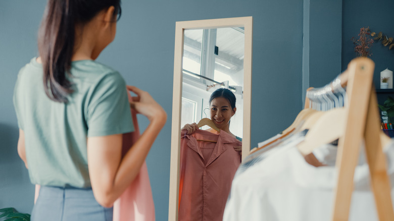 Smiling woman holding clothes 