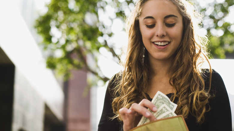 Woman holding a wallet with cash