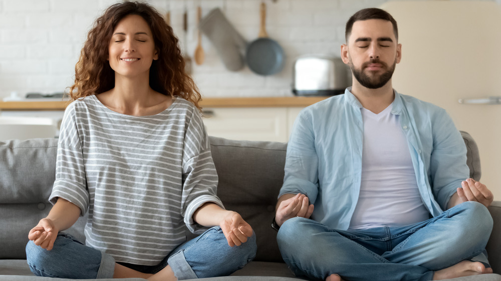 Happy married couple meditating together