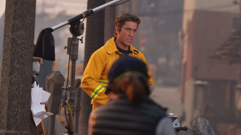 David Muir in a yellow jacket reporting on wildfires
